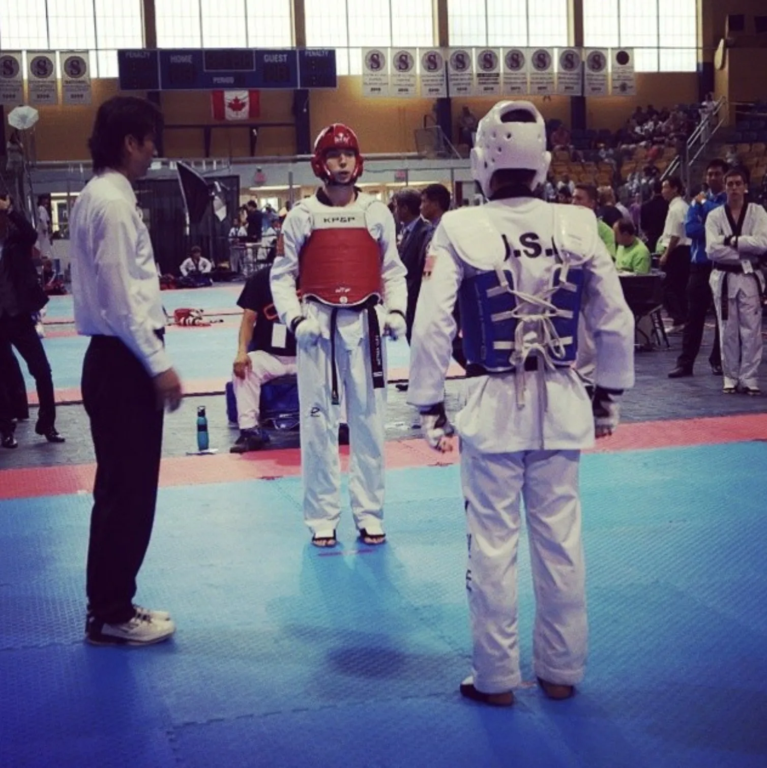 Two competitors face off in Olympic-style sparring at a championship